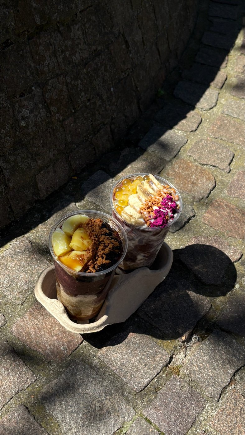 zwei tea99 açaí bowls to-go im kartonträger auf frankfurter kopfsteinpflaster